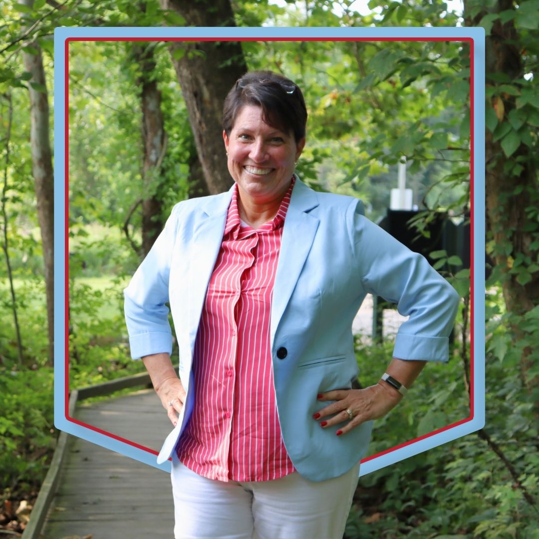 Dr. Blaize poses in front of a wooded background.